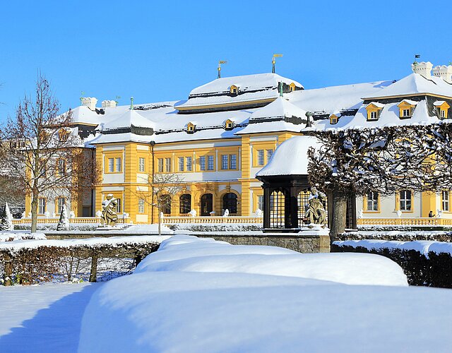 Veitshöchheimer Schloss im Winter, im Vordergrund der schneebedeckte Rokokogarten.