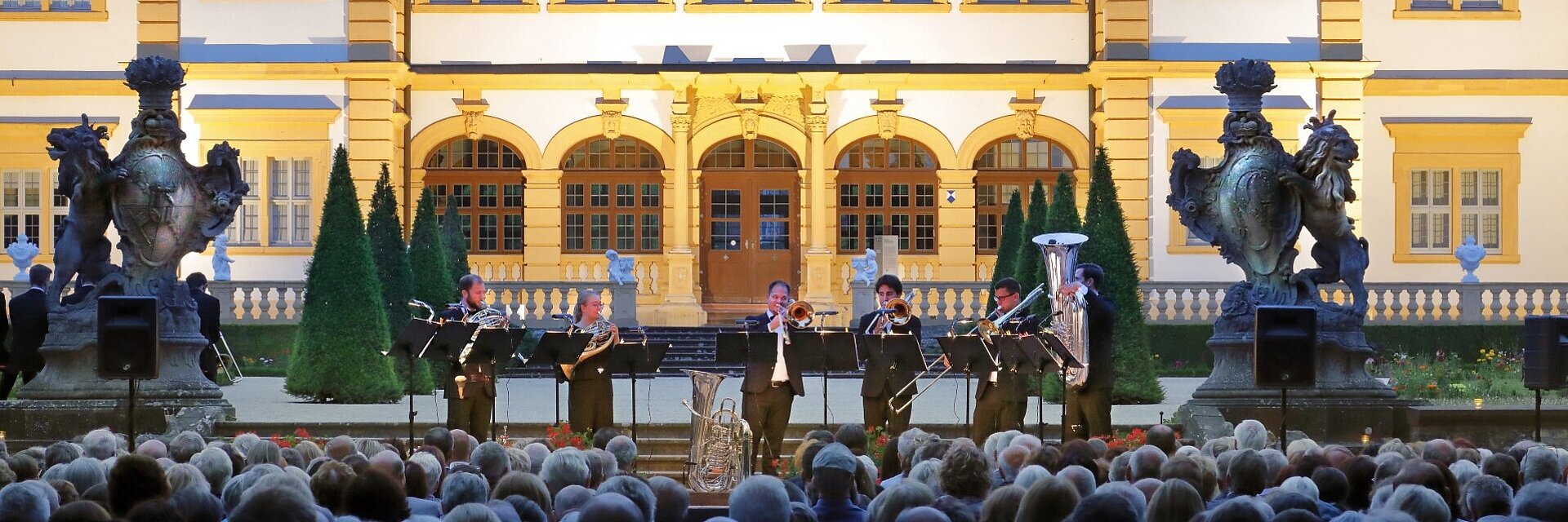 Mozartfest Serenade im Rokokogarten, im Hintergrund die Band vor dem Veitshöchheimer Schloss, im Vordergrund das Publikum