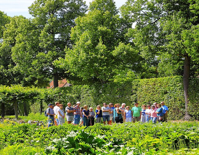 Führung im Rokokogarten Veitshöchheim Besucher lauschen einer Gästeführerin neben dem Küchengarten im Rokokogarten Veitshöchheim.